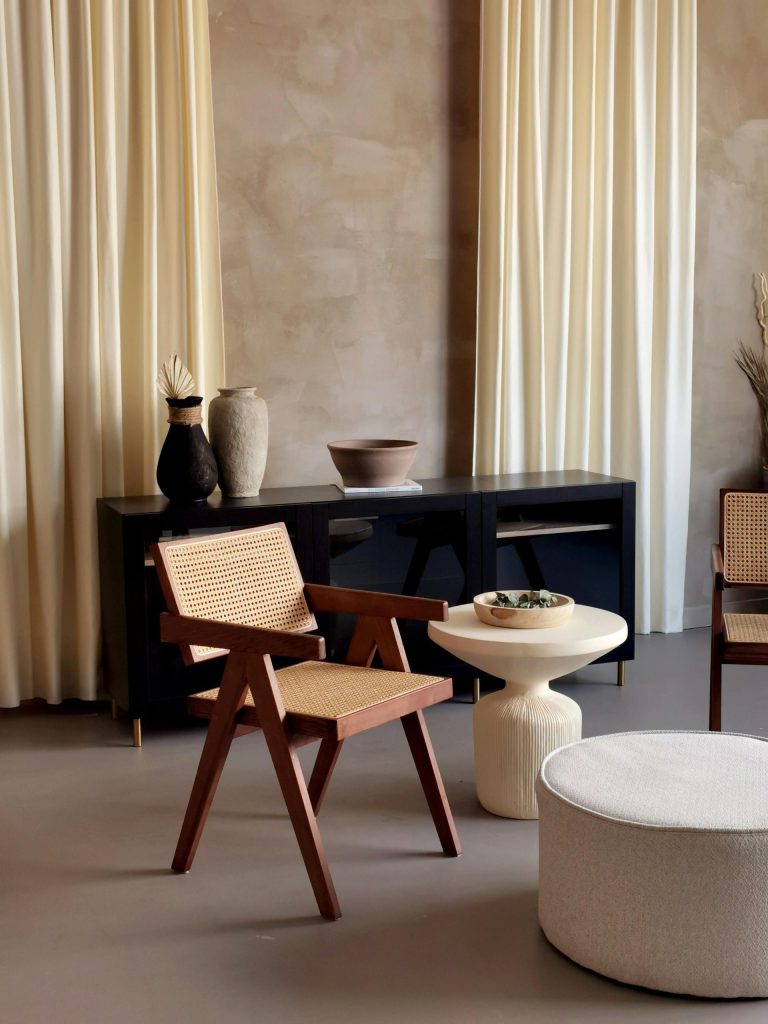 Elegant home studio interior with minimalist design, featuring warm earthy tones, wooden furniture, and woven accents.