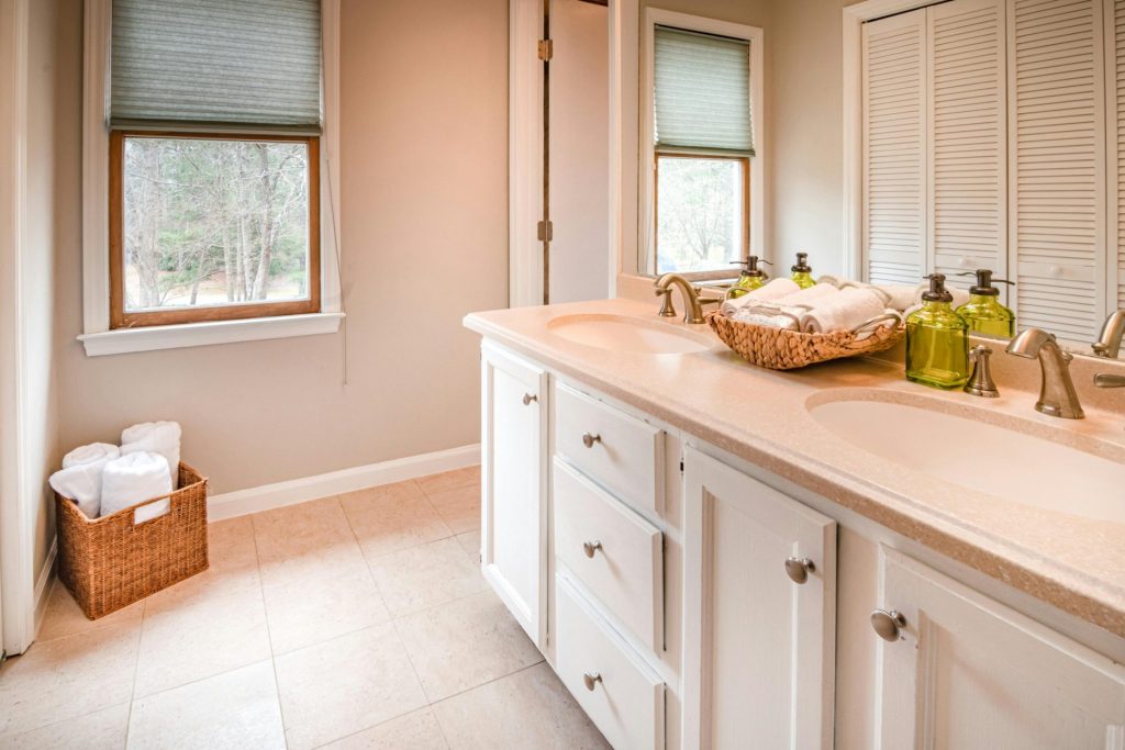 Bright and stylish bathroom featuring a double sink vanity and natural light.